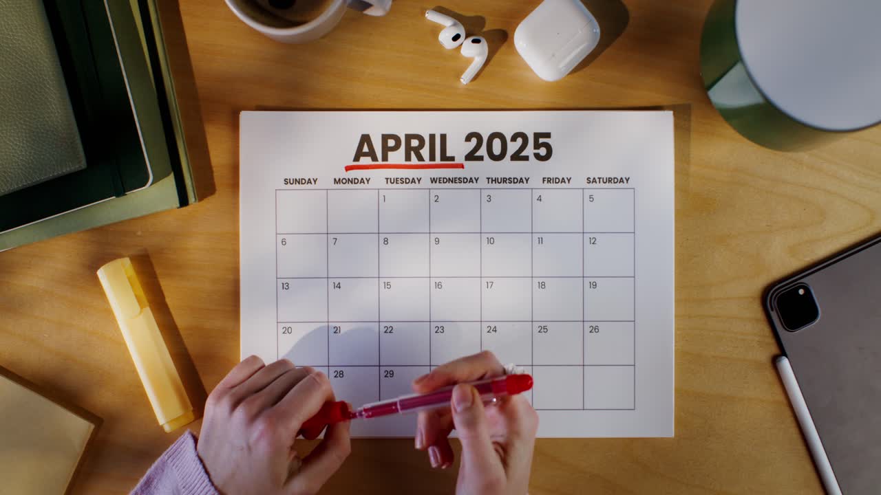 Woman Planning April 2025 Schedule at Desk