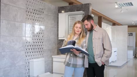 a man and a woman are browsing through a book in the bathroom a man and a woman are examining a book in the bathroom of a beautifully designed modern house featuring artistic decor and glass flooring