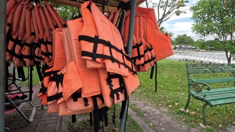 rotating life jackets on a stand outdoors.