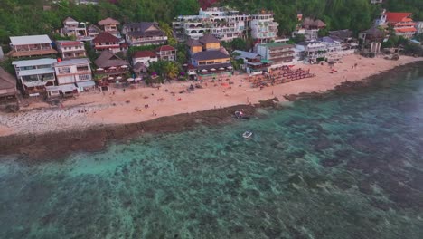 Nach-Oben-Geneigte-Drohnenaufnahme-Der-Hotels-Und-Restaurants,-Die-Entlang-Der-Küste-Von-Bingin-Beach-Gebaut-Wurden