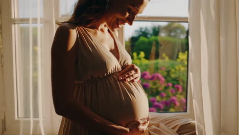 pregnant woman smiling by the window