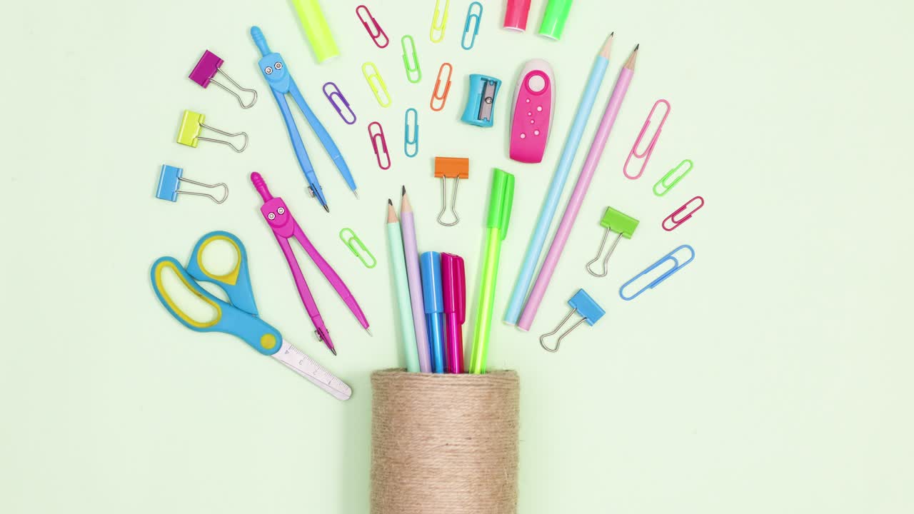 School and writing stationery appear from pencils holder on green theme. Stop motion