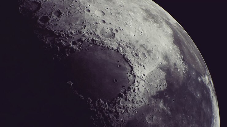 A superfície da lua revela crateras e sombras sob o céu noturno