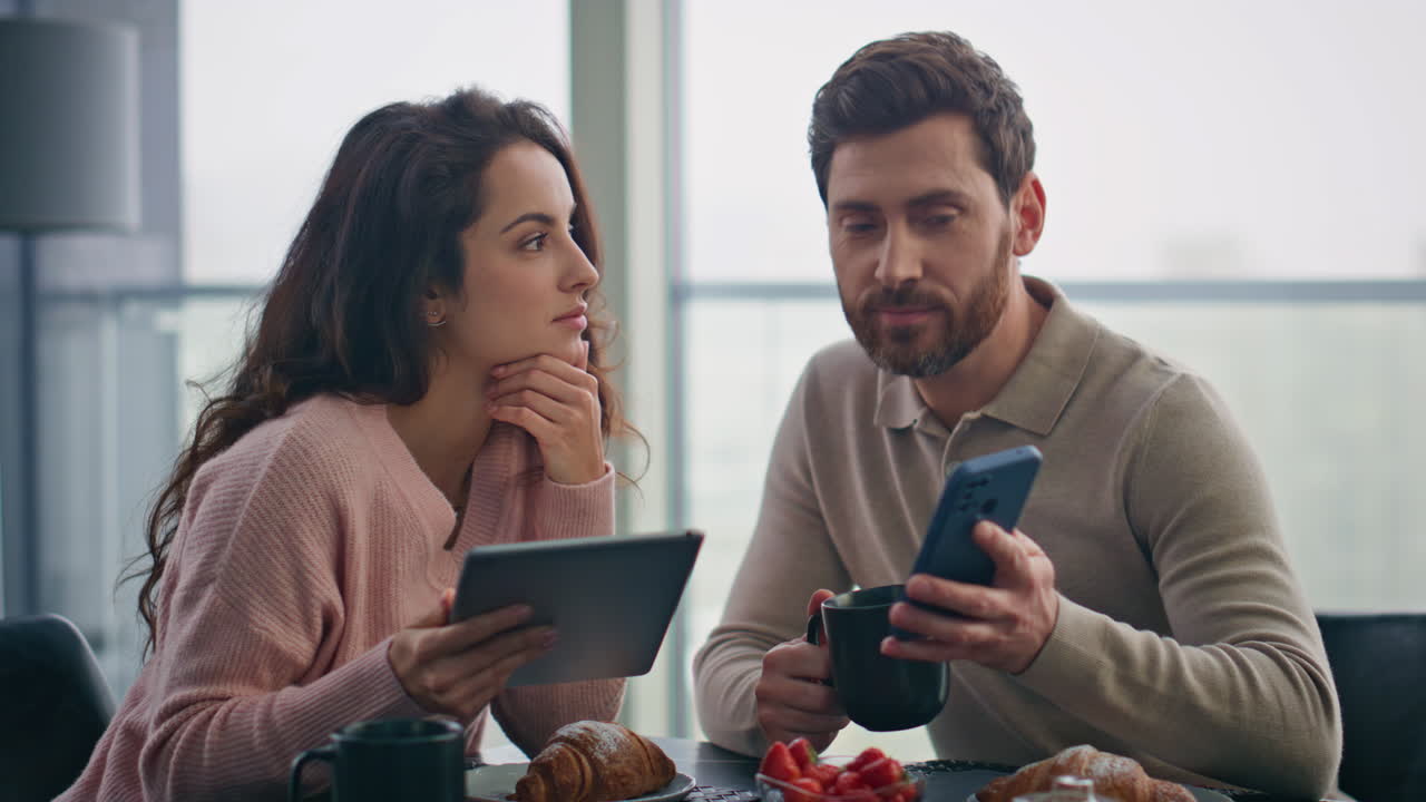 cónyuges amorosos usando aparatos en un primer plano panorámico de la cocina. pareja eligiendo bienes