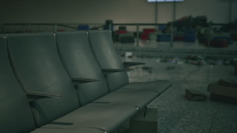 empty airport chairs with luggage in the background