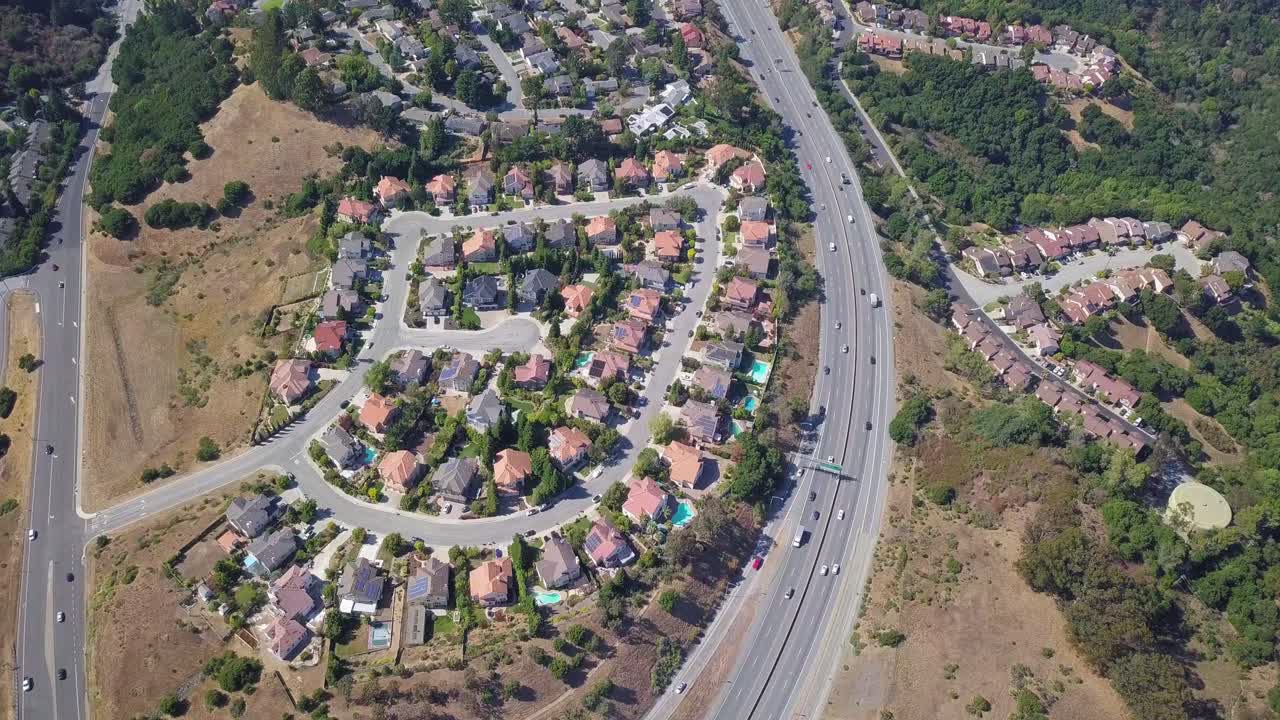 Inquadratura aerea fissa di case e autostrada nei sobborghi della contea di San Mateo, Baia di San Francisco, California, USA