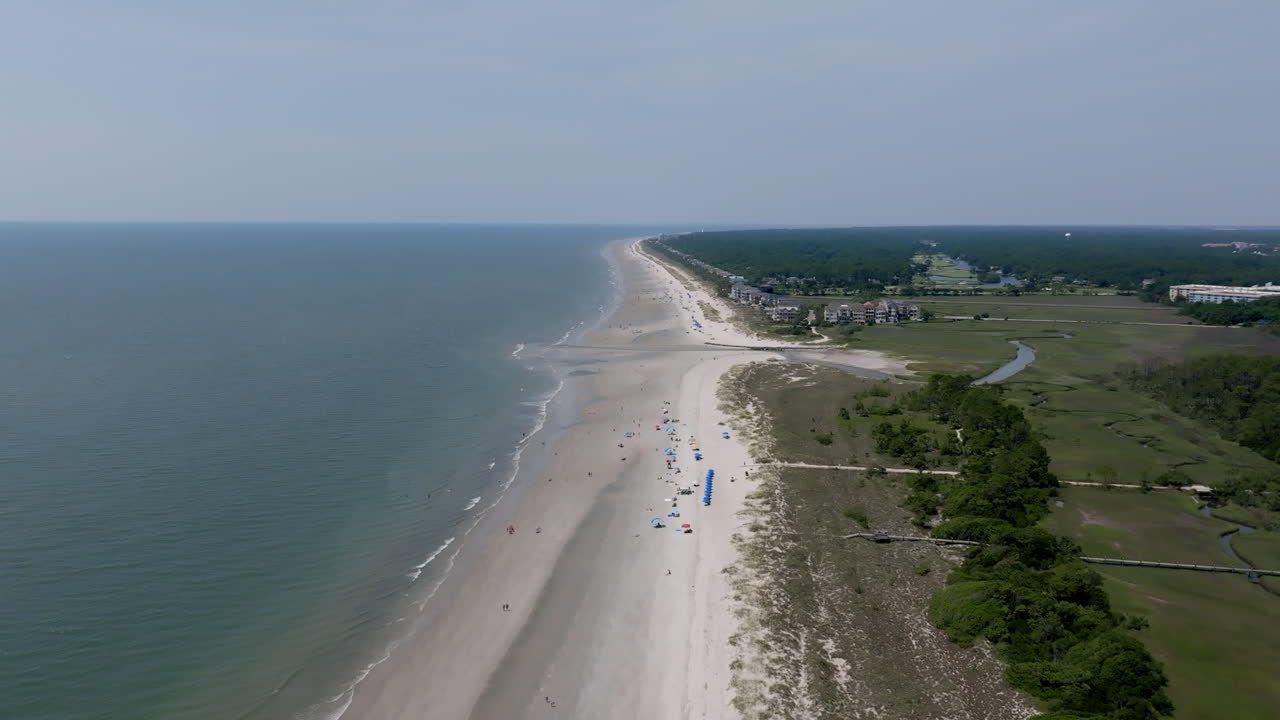A stunning aerial shows Hilton Head’s vast beachline stretching into the distance, bordered by soft surf and serene shoreline development