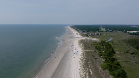 a stunning aerial shows hilton head’s vast beachline stretching into the distance, bordered by soft surf and serene shoreline development