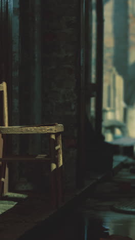 abandoned alleyway with a lone chair resting against wooden fence