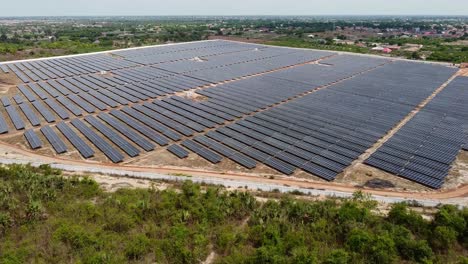 gran granja de energía solar renovable rodeada de bosque verde en un pueblo rural - vista aérea hacia adelante