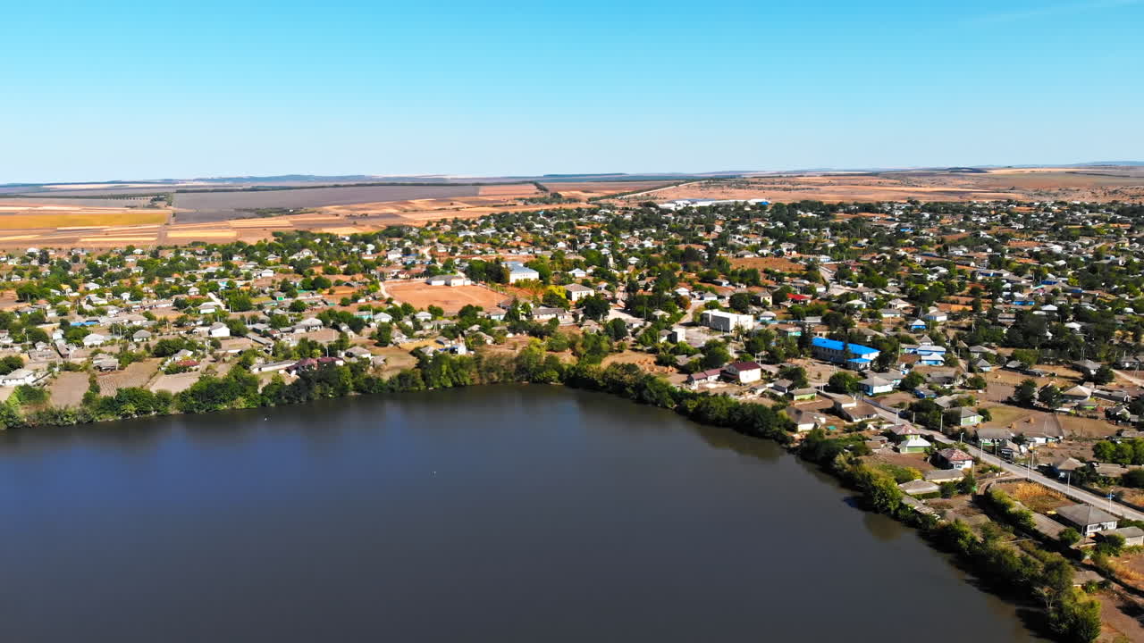Maramonovca village located on the coast of a lake. Aerial drone view with fields on the background in Moldova. Panoramic shot