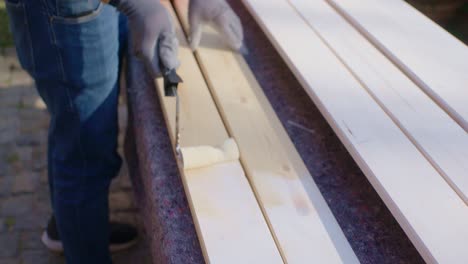 the craftsman is painting two pieces of wood