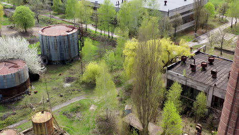 old industrial territory. abandoned buildings of ancient factory. ruined edifices in spring. old brick pipe of industry. aerial view.
