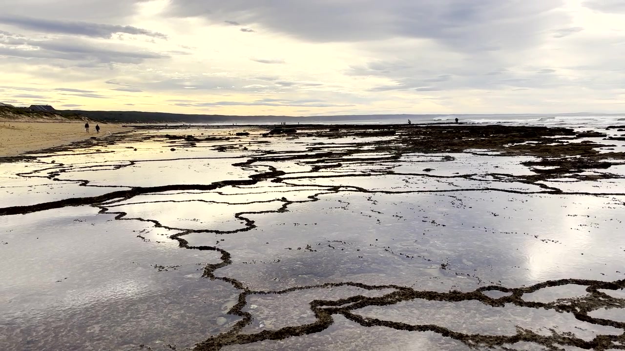 Abstract rock pools at low tide on Witsand coastline during morning sunrise