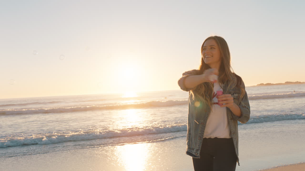 adolescente soplando burbujas en la playa al atardecer divirtiéndose en vacaciones junto al mar disfrutando del verano