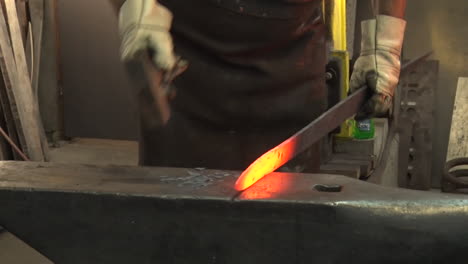 herrero forjando metal en el yunque