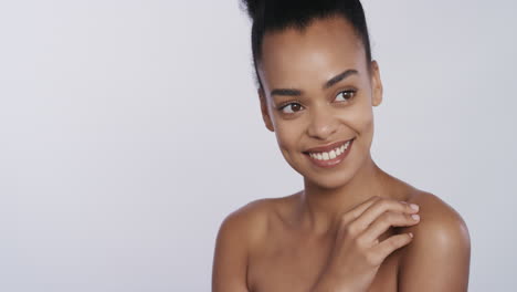 portrait-beautiful-african-american-woman-touching-shoulder-with-hand-caressing-smooth-healthy-skin-complexion-enjoying-perfect-natural-beauty-on-white-background-skincare-concept