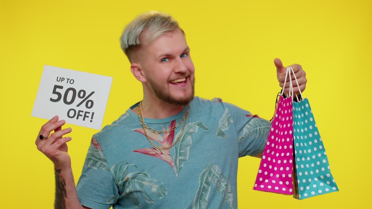 un turista alegre mostrando bolsas de compras y hasta un 50 por ciento de descuento en las inscripciones.