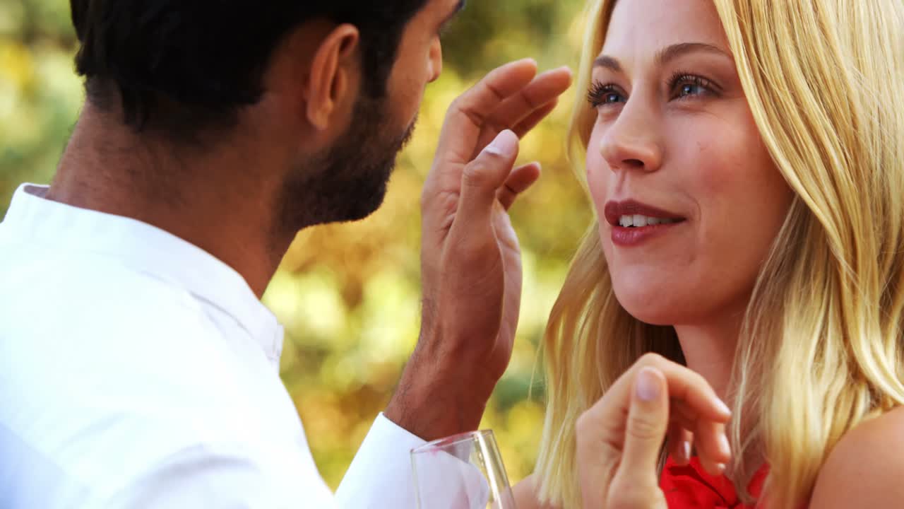 pareja romántica interactuando entre sí mientras toman champán