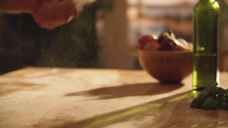 Medium-close-up-of-hand-throwing-flour-in-table-in-slow-motion