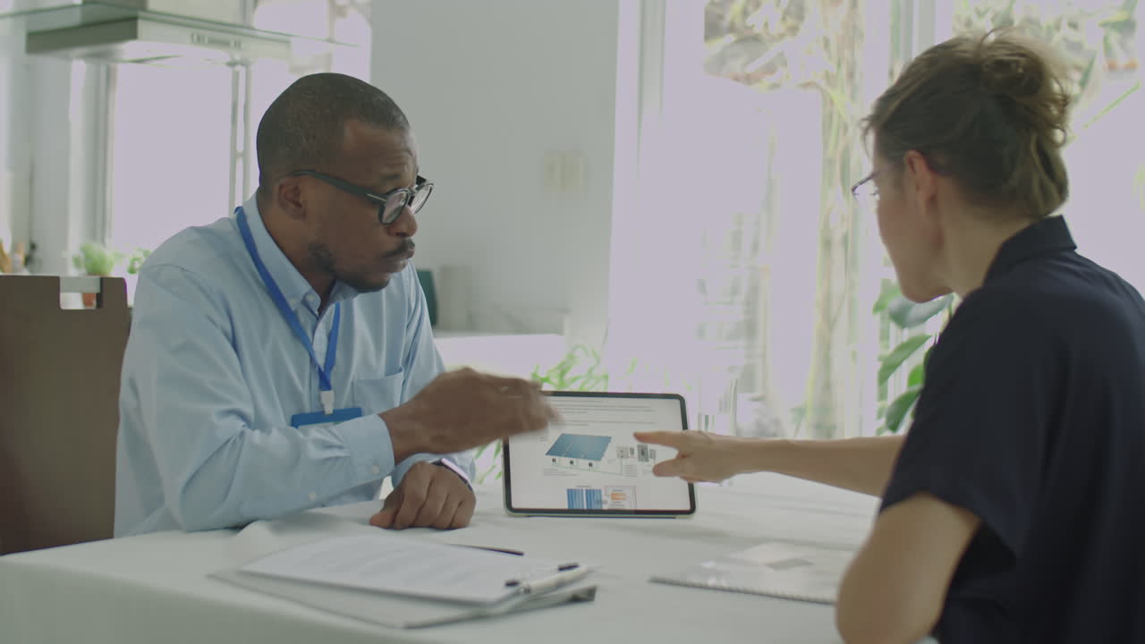 Black Engineer Presenting Green Energy Project on Tablet to Client