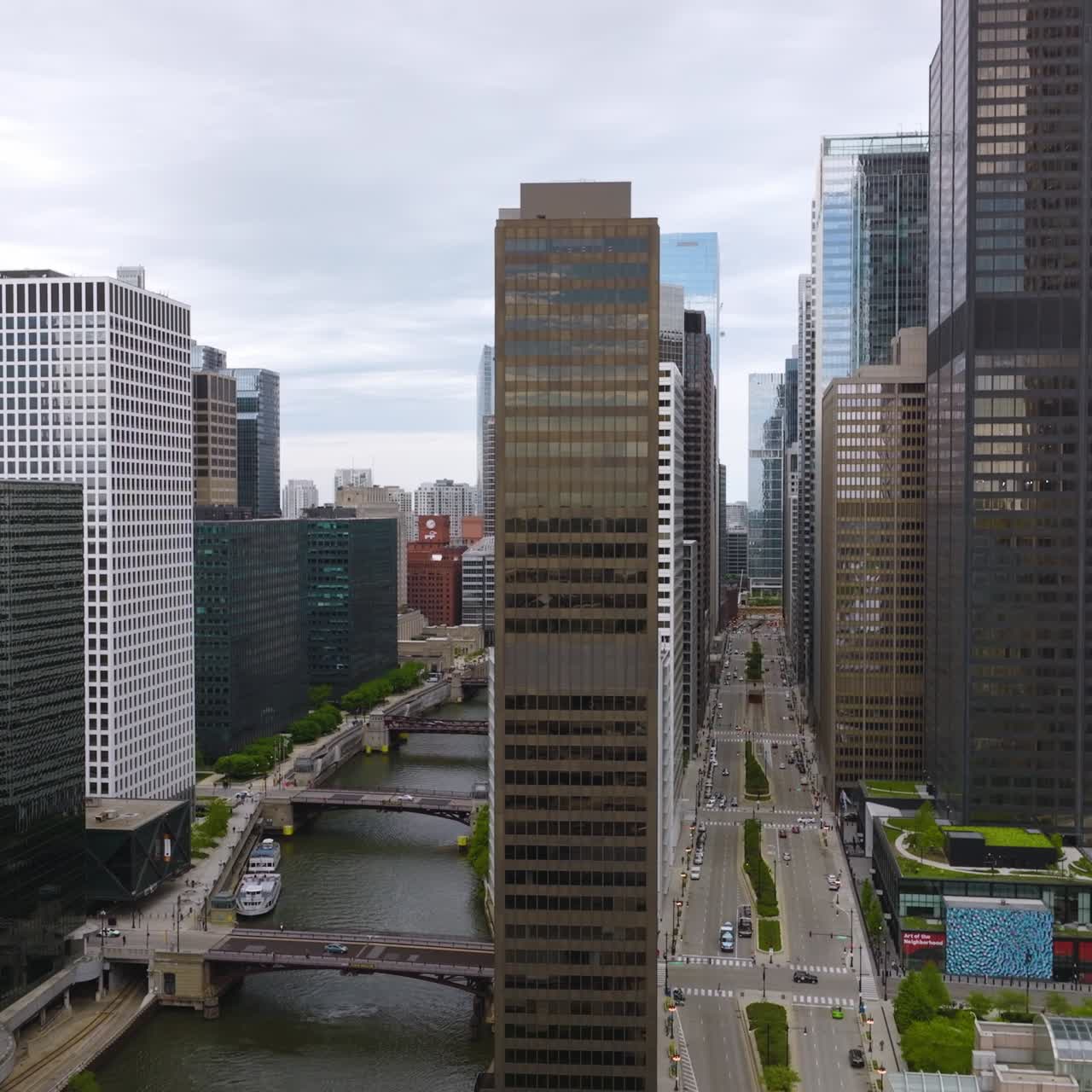 Straight row of buildings between Chicago River and multi0lane road. Drone footage slowly rising along the buildings