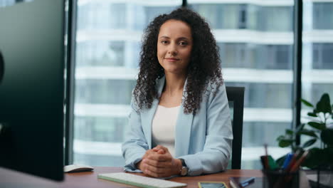 Portrait-woman-office-manager-sitting-at-desk.-Latin-businesswoman-working.