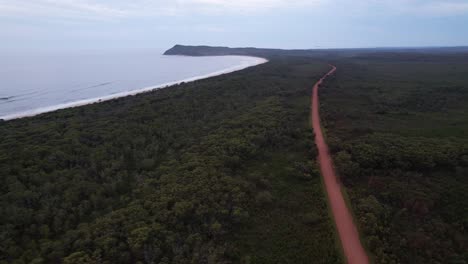 Diamond Head Road Through Forest Trees With View Of South Beach And Diamond Headland. Barrington Coast, NSW, Australia. aerial shot