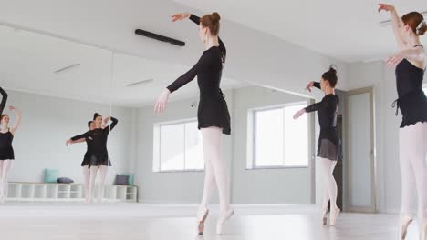 caucasian female ballet dancers practicing a dance routine during a ballet class