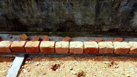 se coloca el ladrillo, se construye el fundamento de la casa, los trabajadores trabajan en un sitio de construcción en la india, se constrúe una casa con piedra roja, se trabaja con cemento