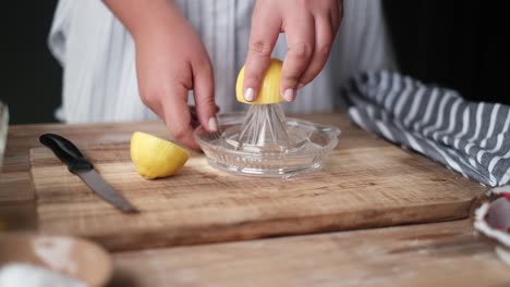 Entsaften-Einer-Zitrone-Von-Hand-Mit-Einer-Zitronenpresse-Aus-Glas