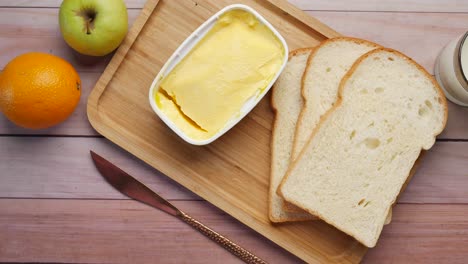 fresh butter in a container with bread on white background