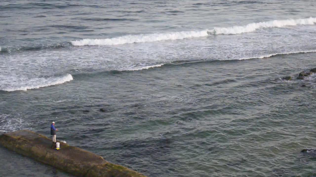 Man rock fishing at Bar Beach-Merewether Beach, NSW, Australia