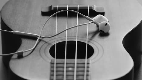 ukulele and earbuds: a monochrome still life