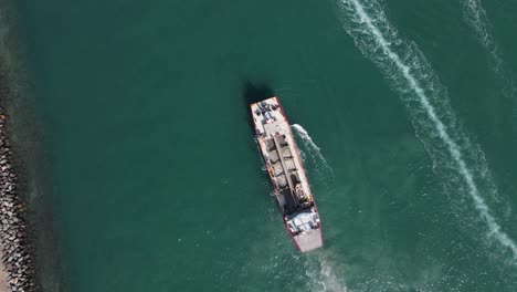 large ship powering through the waterway causing harmful disturbance to a highly sensitive marine precinct high drone view looking down