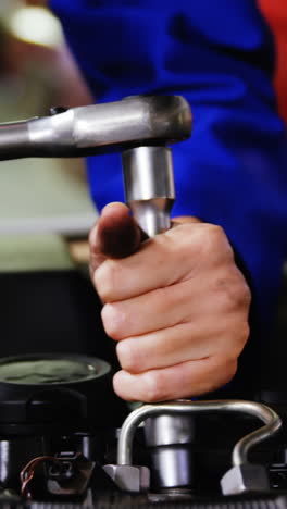 manos de una mecánica que hace servicio a un coche