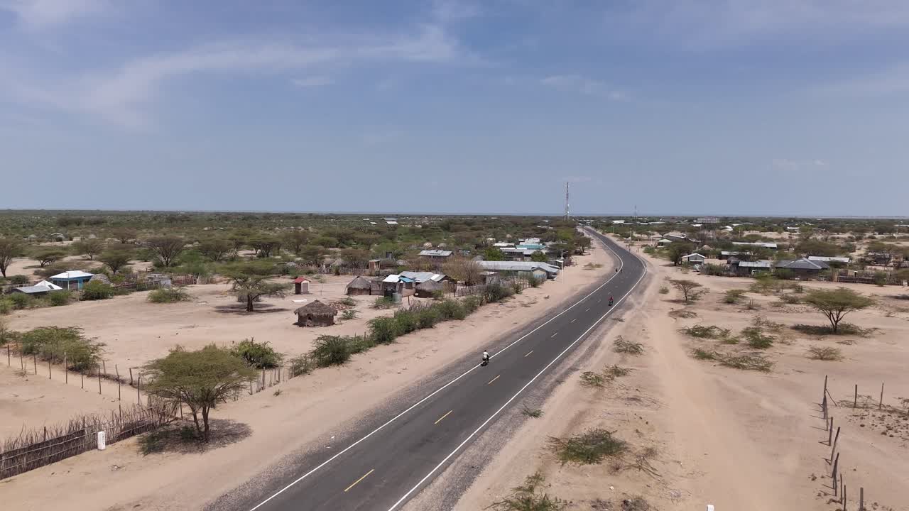 케냐의 투르카나 호수 사막 지역의 새로운 도로에서 모터사이클의 드론 뷰
