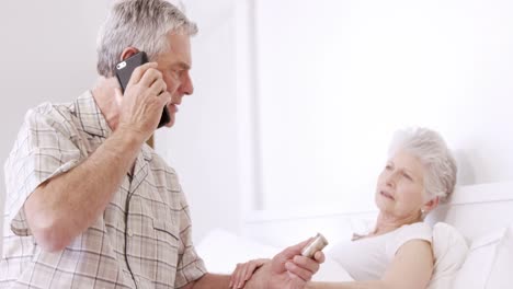 Senior-man-on-phone-call-holding-pills