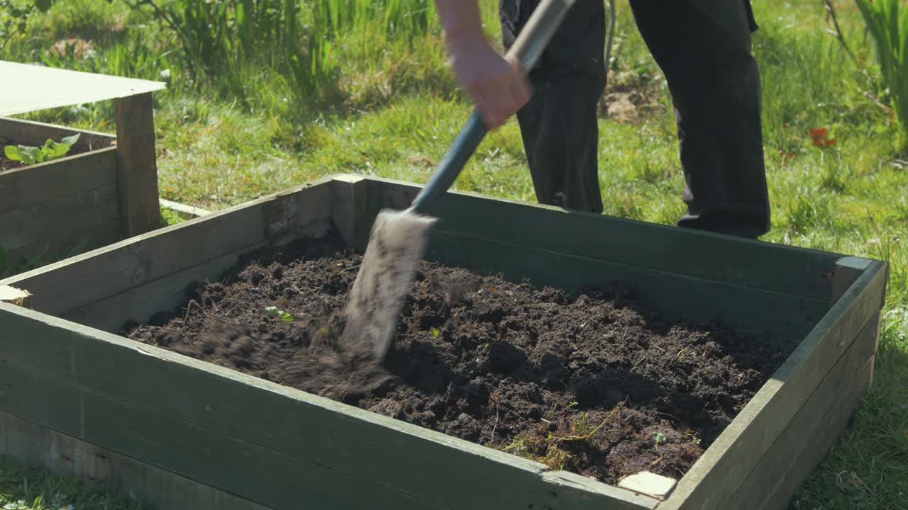 rompiendo el suelo con una cama de jardín levantada con una pala
