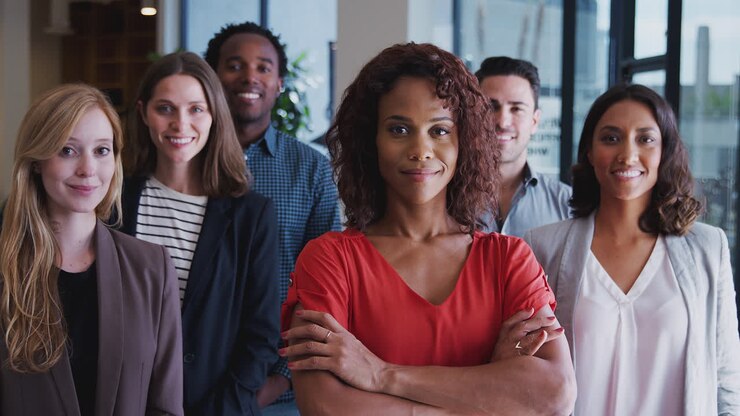 Portrait Of Multi-Cultural Business Team With Female Boss Standing In Modern Open Plan Office