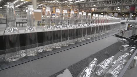 conveyor belt with empty glass bottles for inspection in a factory