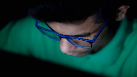 young man working on computer at night