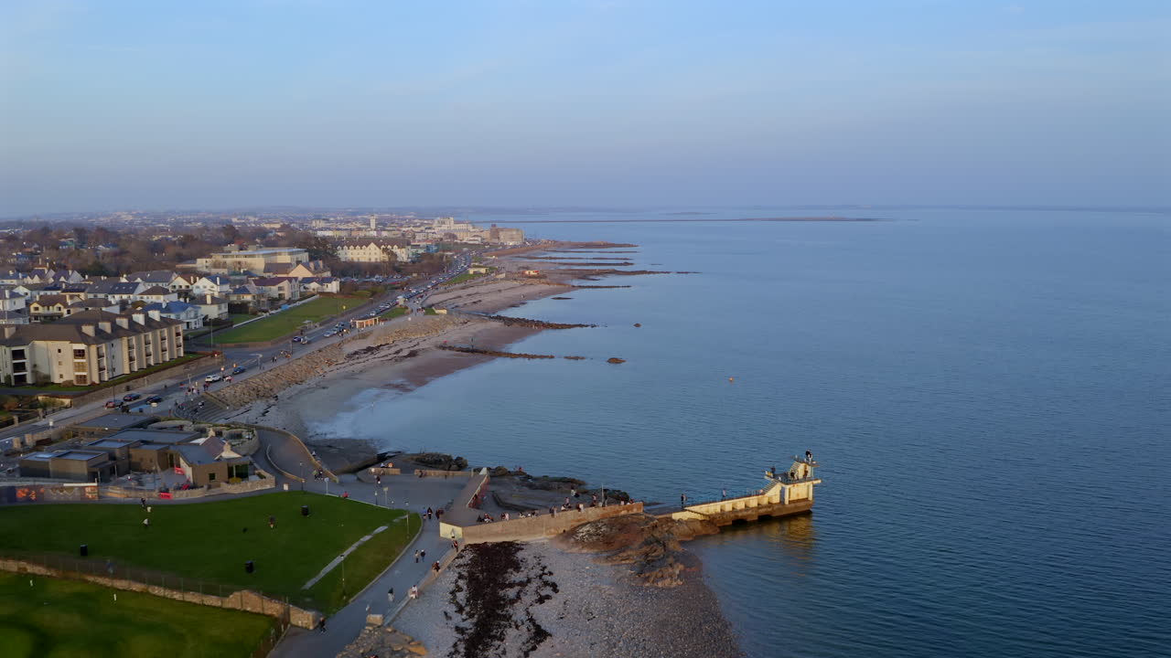 Aerial dolly to Blackrock Diving Board with Mutton Island in backdrop, surrounded by calm ocean waters near Salthill Promenade in Galway