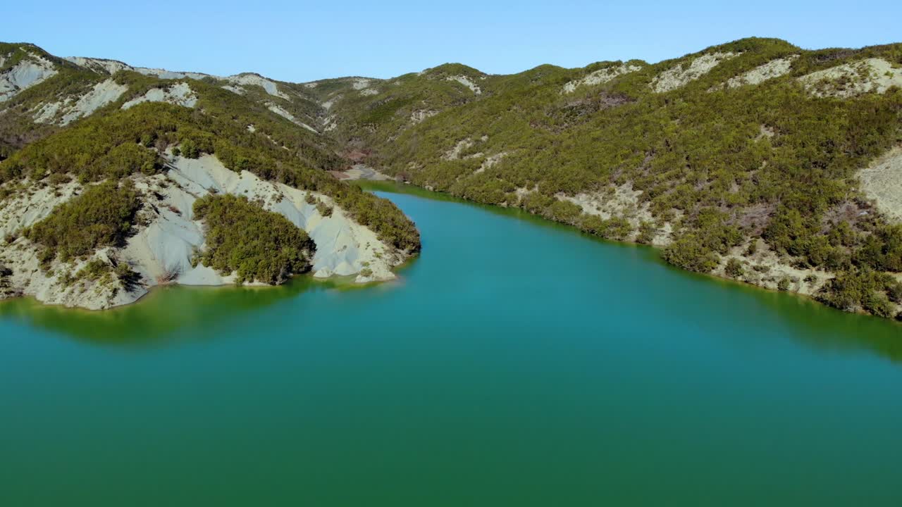 Mountain lake with green water surface on a beautiful sunny day with clear bright blue sky