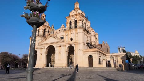 Low-level-walk-through-shot,-between-street-lamp-and-block-letter-sign,-A-MO-CBA,-I-LOVE-CORDOBA-toward-famous-Cathedral-of-Cordoba,-Our-Lady-of-the-Assumption-at-San-Martin-Plaza