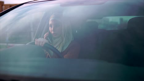 woman driving a car and talking on the phone