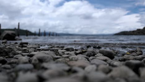 Rocky-shore-of-Nahuel-Huapi-lake-on-cloudy-day,-selective-focus,-Argentina