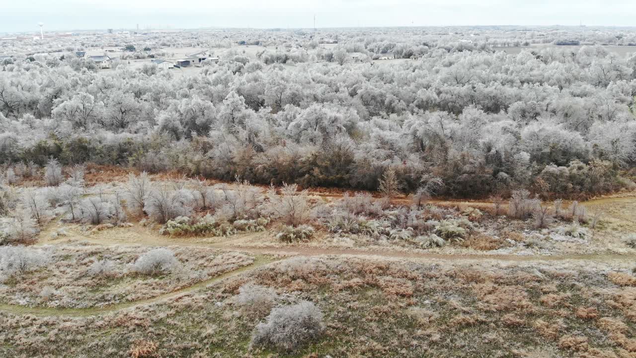 작은 관목과 산책로가 있는 매우 얼어붙은  ⁇  위를 날아다니는