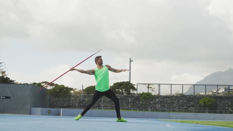 vista lateral de un atleta caucásico lanzando una jabalina