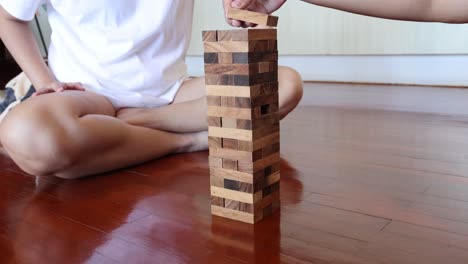 person playing jenga, tower collapses